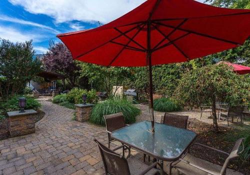 Outdoor lounge area with tables and red umbrellas at The Enclaves at Packer Park apartments for rent