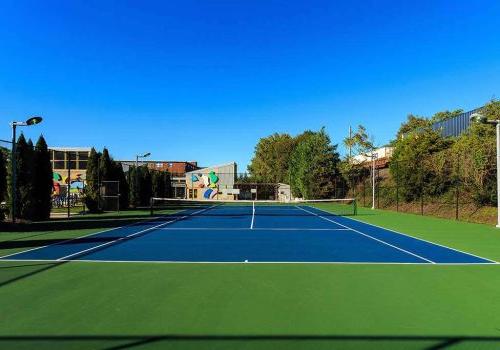 An outdoor tennis court at Enclaves at Packer Park apartments for rent