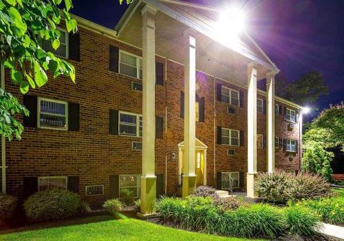 Lighted exterior view of a residential building at night at Warrington Crossings apartments for rent