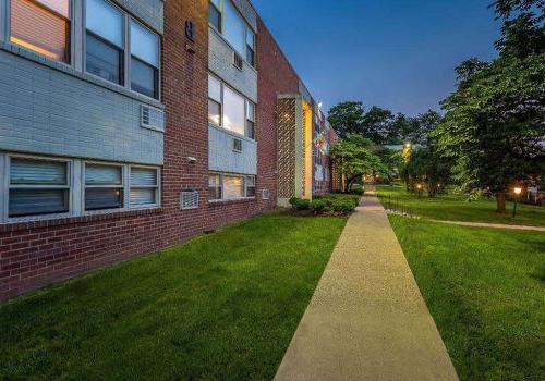 Walkway to residential brick buildings at Willow Bend apartments for rent in Philadelphia, PA